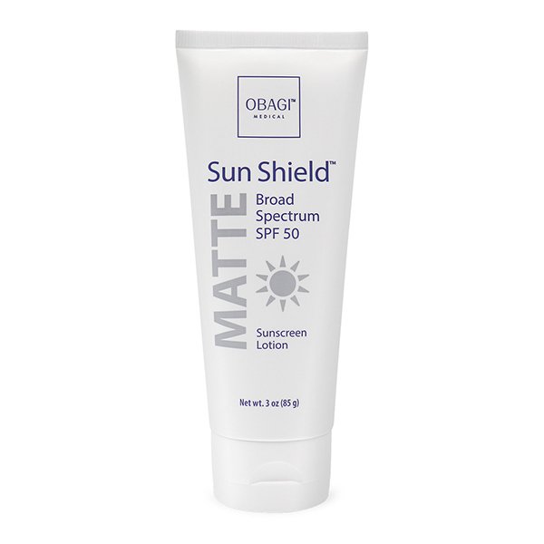 A white tube of Obagi Sun Shield Matte Broad Spectrum SPF 50 Sunscreen Lotion. The front label displays the brand name, product name, sun icon, and size indication of 3 oz (85 g). The tube has a matte texture and a flip-top cap.