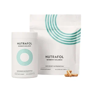 A white container and refill pouch of Nutrafol Women's Balance dietary supplement are displayed. Both packages feature a modern design with teal circular lines. Several capsules are placed in front. The container holds 120 capsules and promotes hair growth.